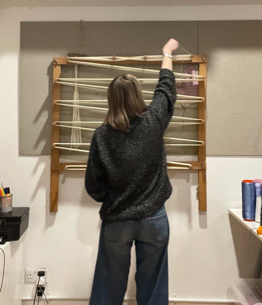 My process Measuring out a warp on a warping frame.