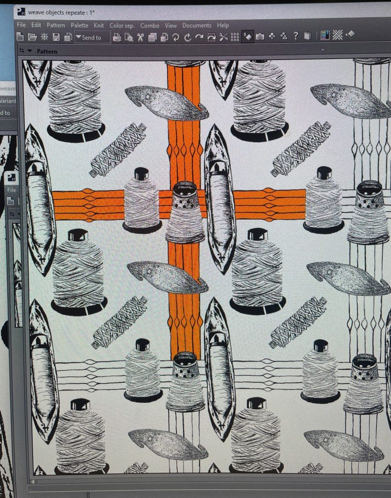 My process a computer screen with a Jaquard design that has illustrations of weaving shuttles and thread