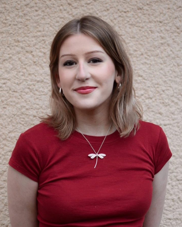 Millie facing the camera wearing a red t shirt