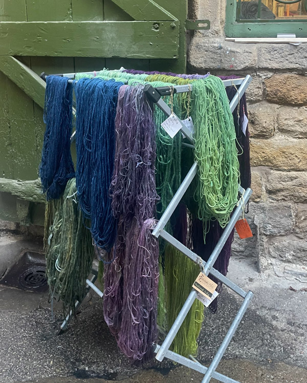 dyed wool drying on a rack